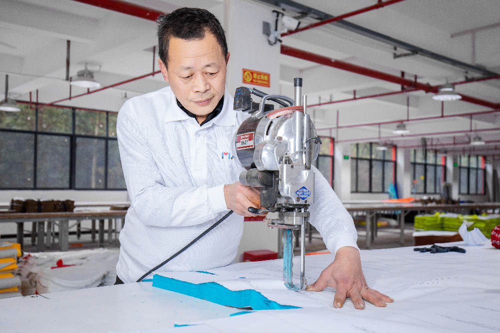 A worker uses an electric shearto cut fabric with optimum efficiency and precision.