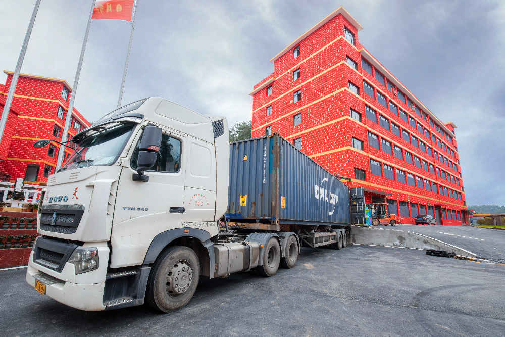 A large truck is parked outside the factory and quality inflatable products are being prepared for shipment.